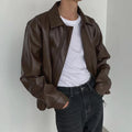 Model in brown boxy faux leather jacket over a white tee, front view