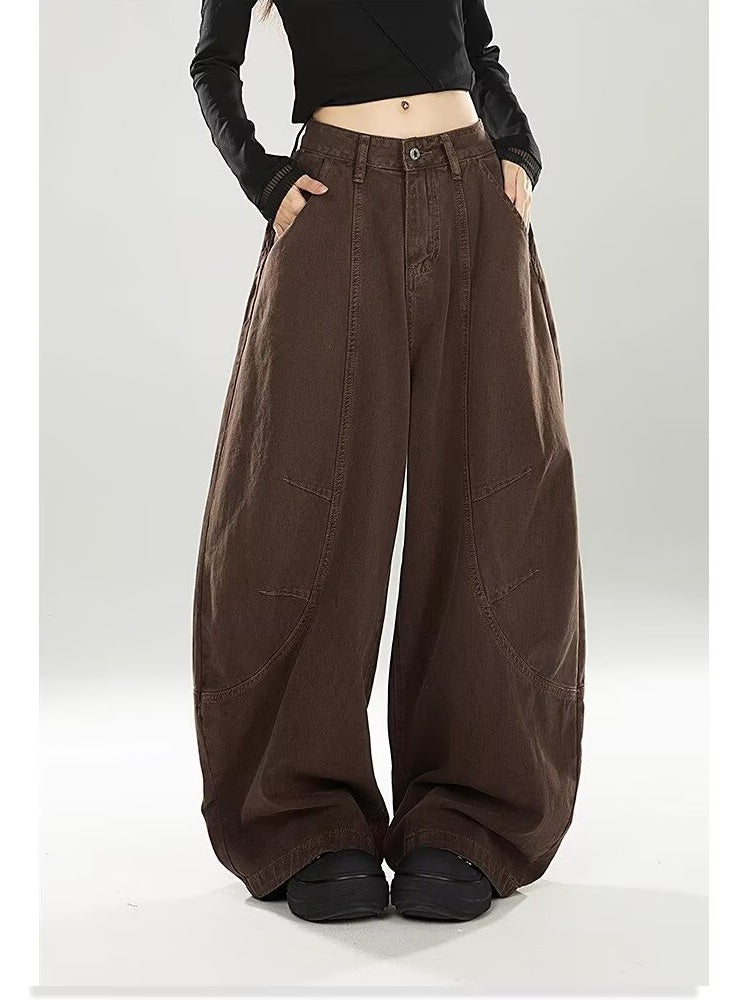 Model in chocolate brown barrel-leg jeans with a cropped black top, front view