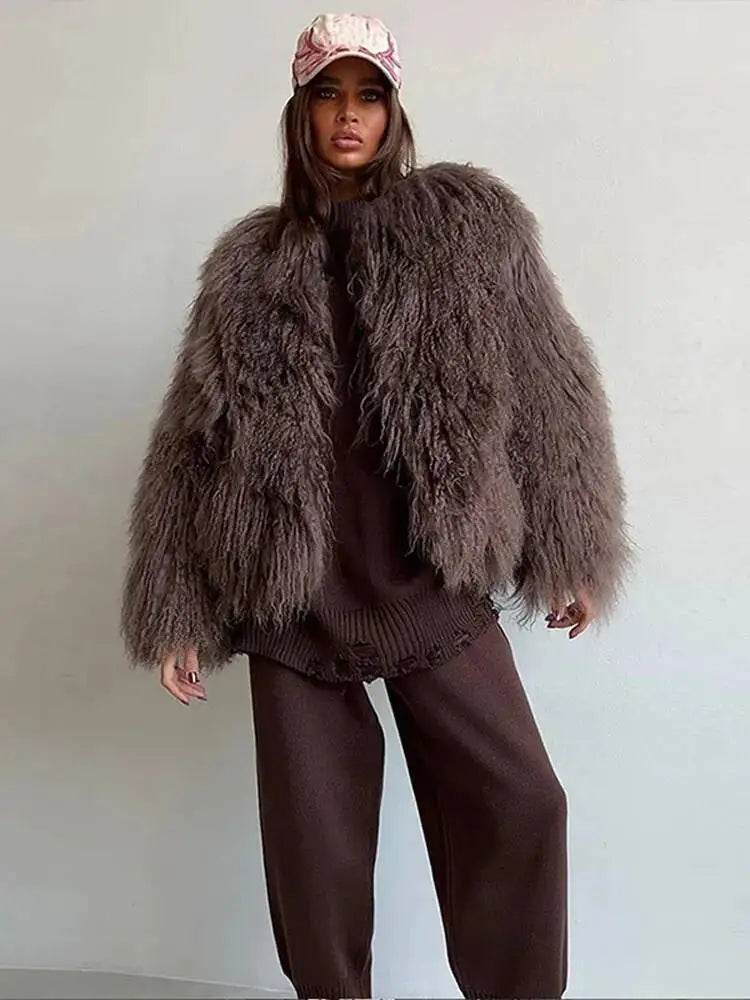 Model in shaggy faux fur cropped jacket worn open over a brown knit