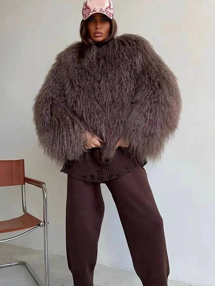 Model holding a shaggy faux fur cropped jacket closed, front view