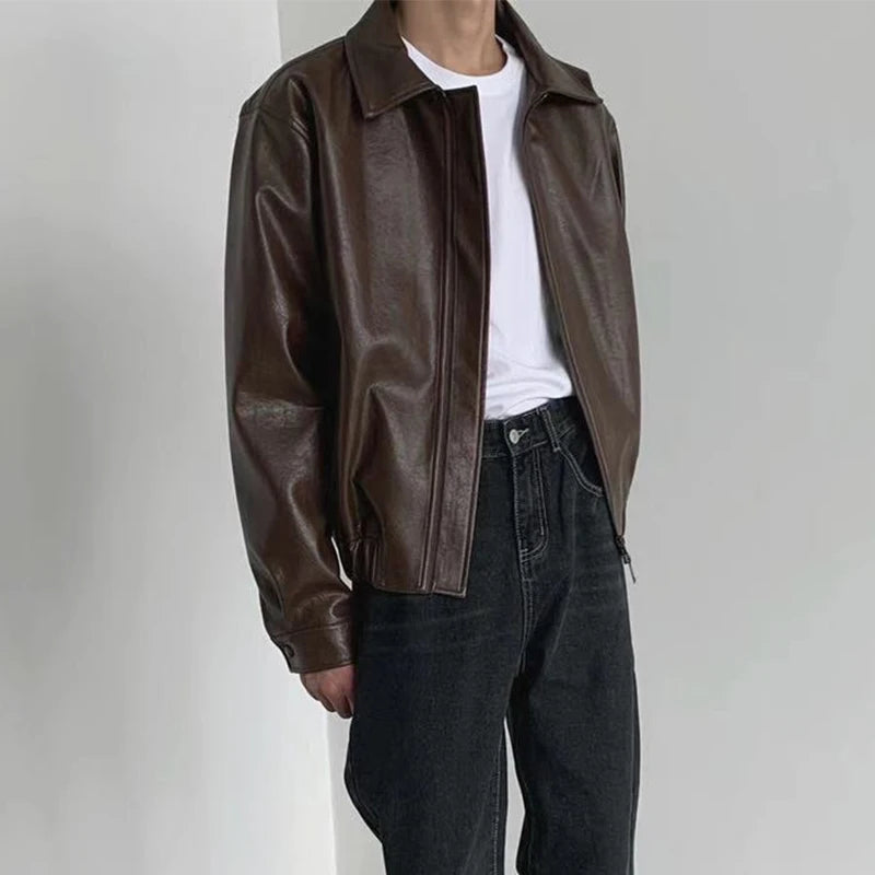 Brown faux leather jacket worn open with jeans, three-quarter view