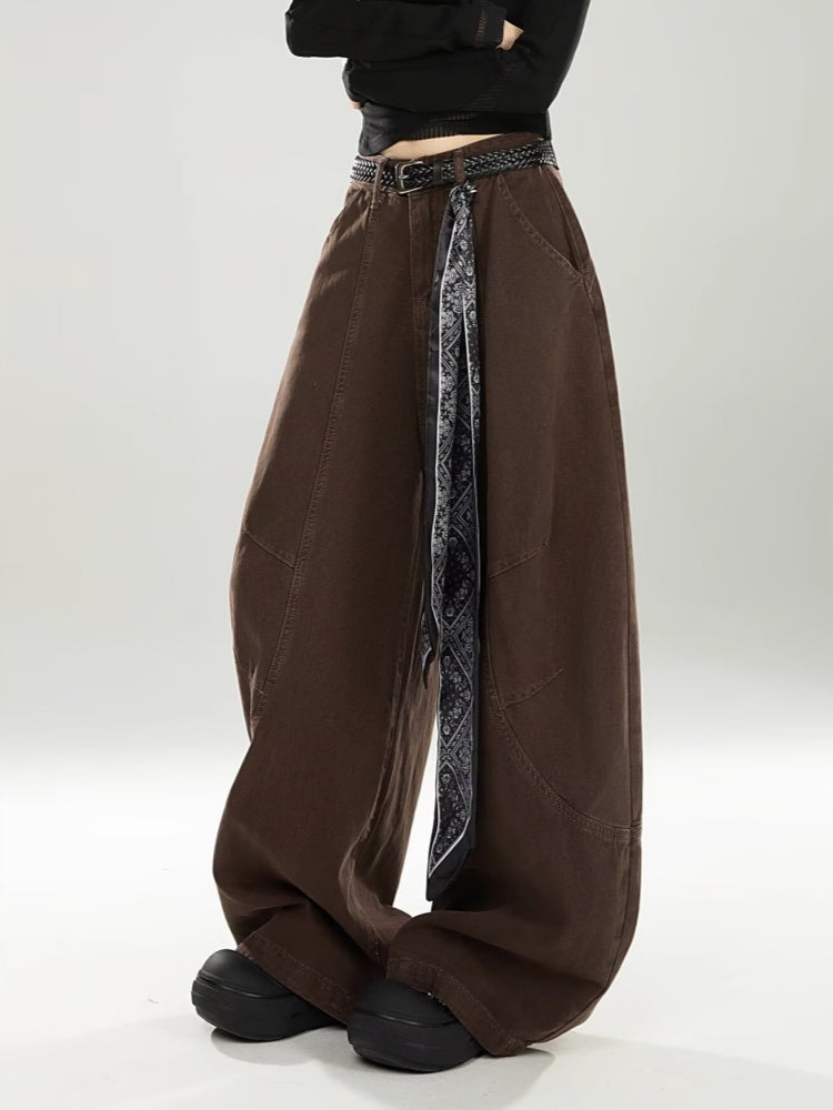 Model in chocolate brown barrel jeans and black platform shoes, three-quarter view