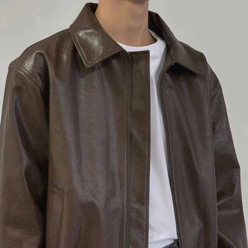 Close-up of point collar and zip on brown faux leather jacket