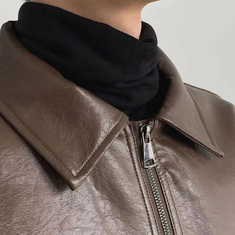 Detail of collar and silver zip pull on brown faux leather jacket
