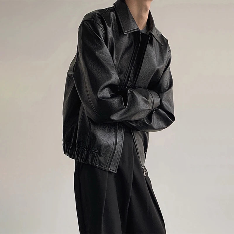 Model in black boxy faux leather jacket with arms crossed