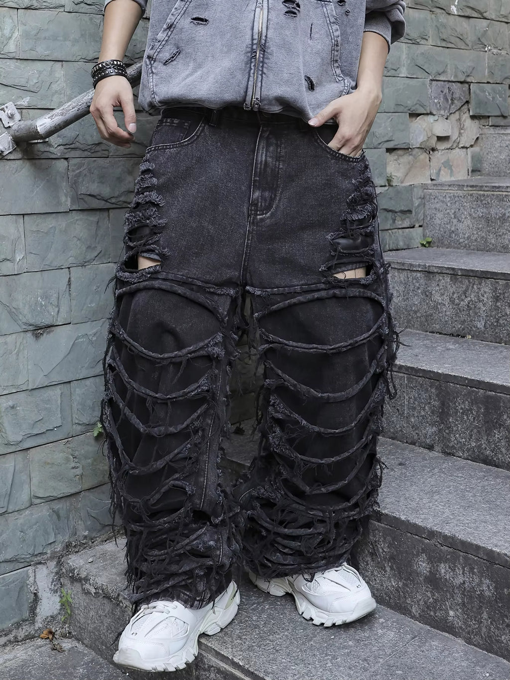 Men's black jeans. With a design of (ripped holes) and tassels. In a street trend style.