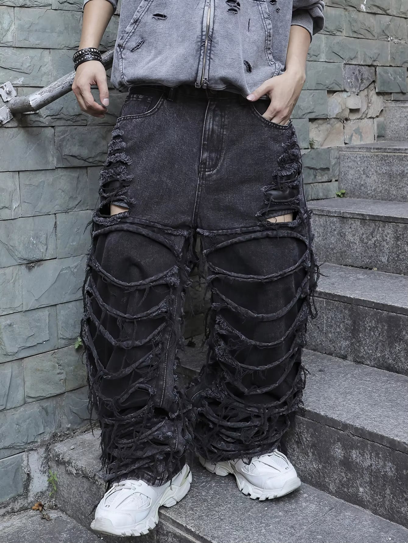 Men's black jeans. With a design of (ripped holes) and tassels. In a street trend style.