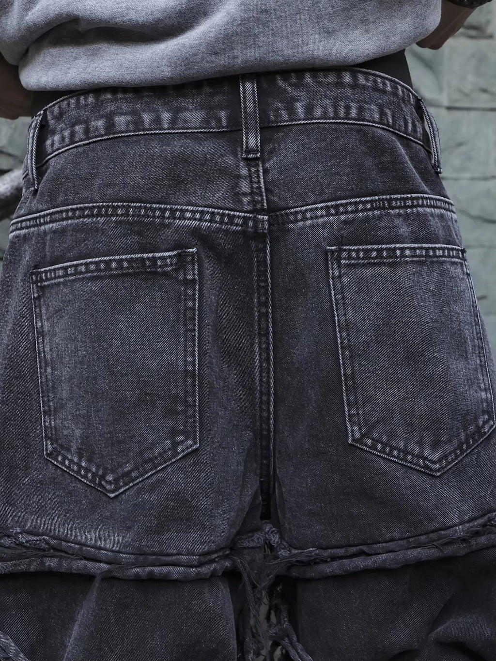 Men's black jeans. With a design of (ripped holes) and tassels. In a street trend style.