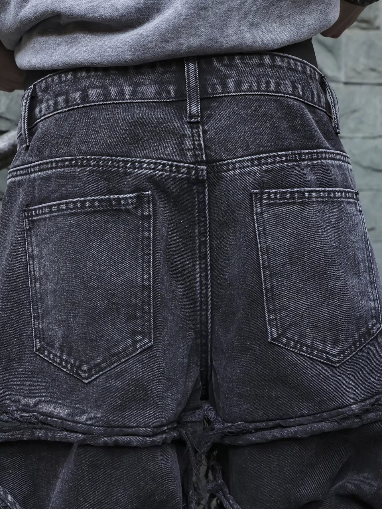 Men's black jeans. With a design of (ripped holes) and tassels. In a street trend style.
