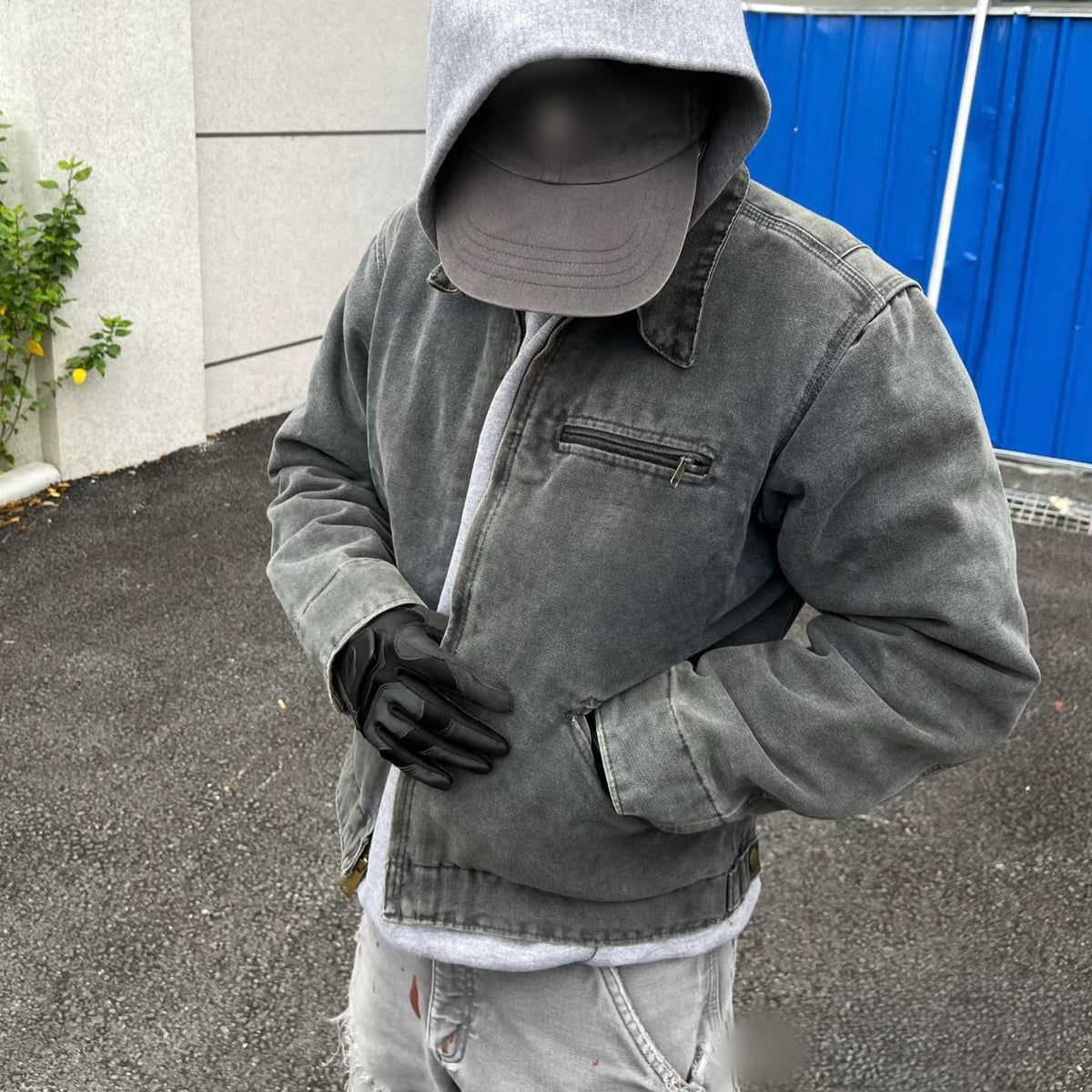 Model in the faded gray canvas work jacket over a gray hoodie, front view