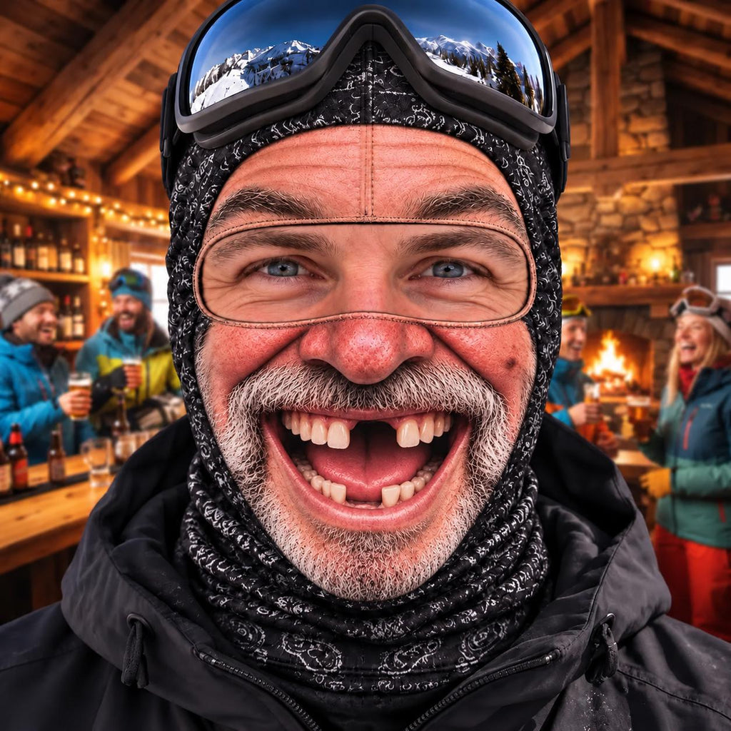 May include: A black patterned balaclava worn under dark ski goggles with a reflective lens. The balaclava features a detailed white print on a black fabric base, covering the head and neck, while the goggles rest on the forehead.
